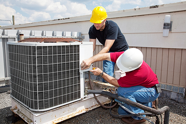 Men repairing industrial air conditioner